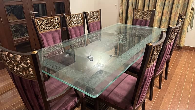 Glass table with wooden stylish , classical stand . 8 maroon chairs 1