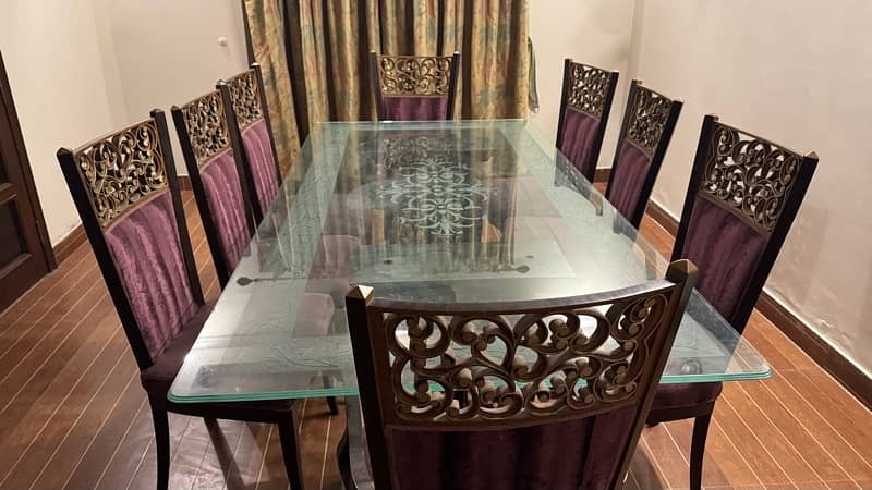 Glass table with wooden stylish , classical stand . 8 maroon chairs 2