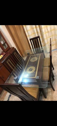 Wooden dining table with glass top