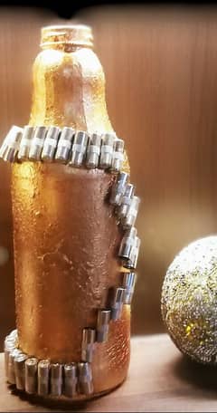 handcrafted thick glass bottles decorated with nutsscrews buttons .