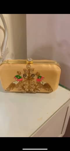 Stylish golden clutch with embellishment