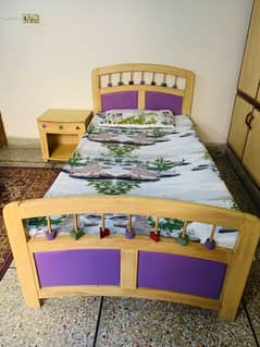 Single bed with side table without mattress.