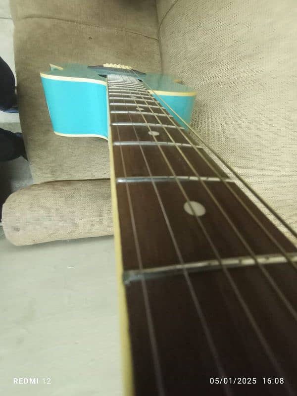 A light blue full size acoustic guitar with all accessories 7