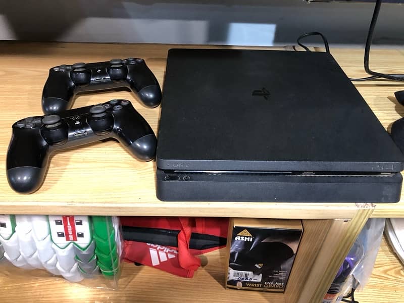 ps4 slim with 2 controllers and injustice game 1