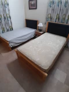 2 single wooden beds with spring mattresses