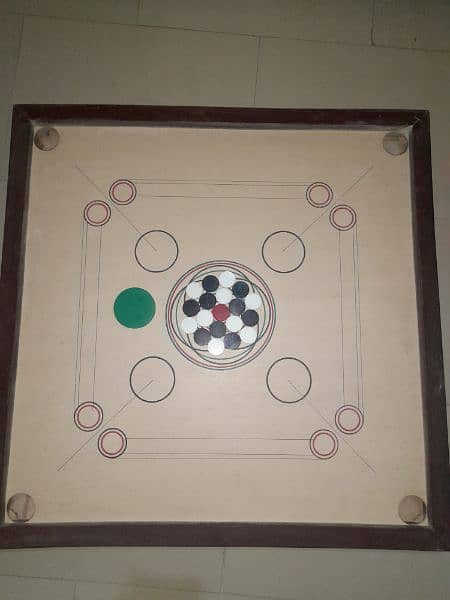 carrom with its all black,white and a red coin + stricker 1