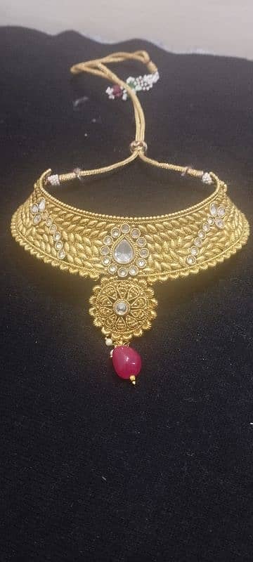 A golden red set and green earrings with bindiya 0