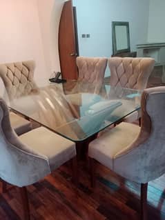 beauful glass dining table ,wooden base with upholstered beige chairs