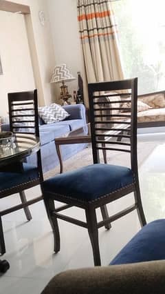 round dinning table with glass top with 4 beautiful chairs along