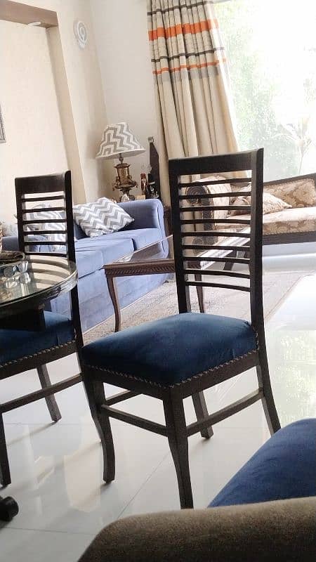 round dinning table with glass top with 4 beautiful chairs along 0