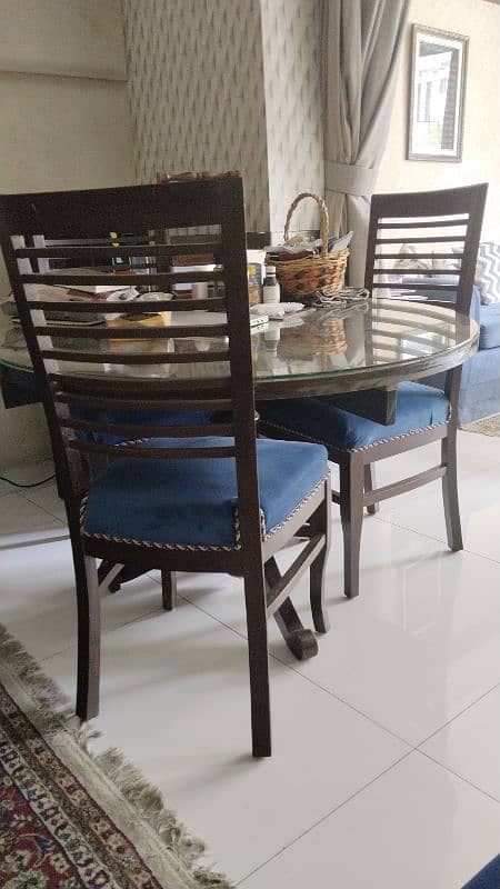 round dinning table with glass top with 4 beautiful chairs along 2