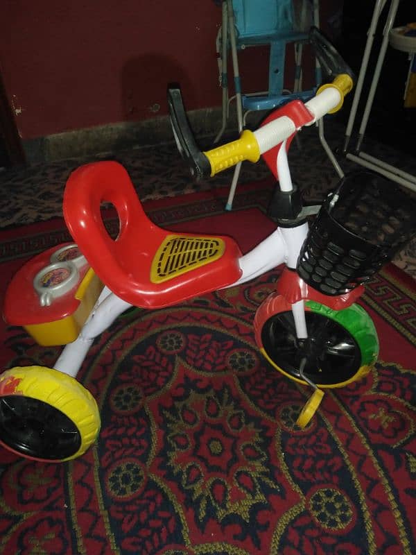 kids cycle and a high chair 0