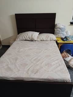 wooden bed with a brand new pack mattress.