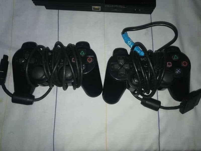 ps2 console with two controllers , 10 dvd games and data cables 2