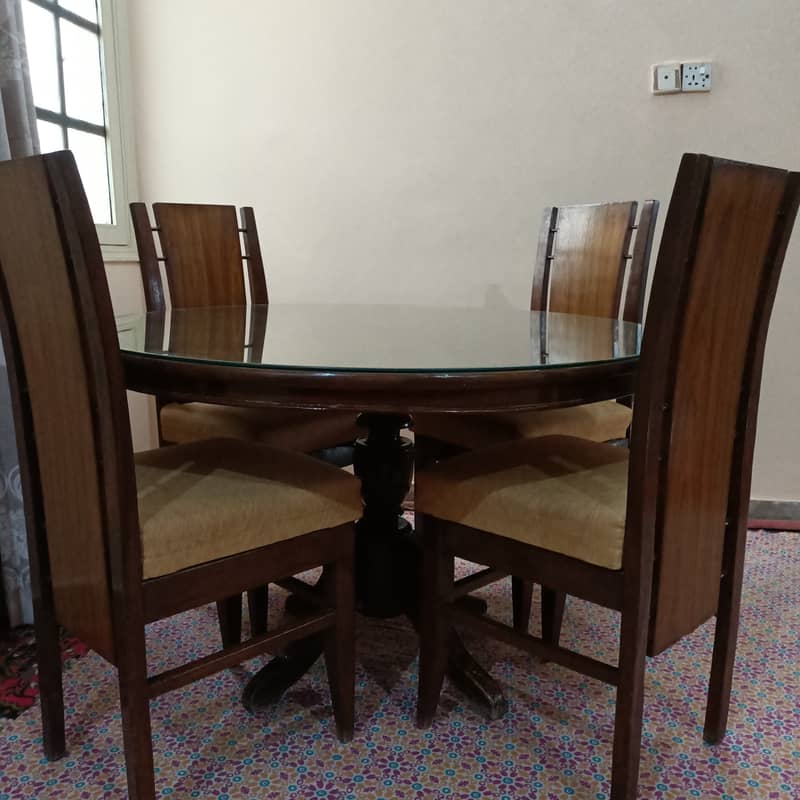 Round Dinning Table with 4 chairs. Glass placed over wooden top 0