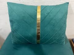 A rectangular teal velvet throw pillow with a vertical gold stripe