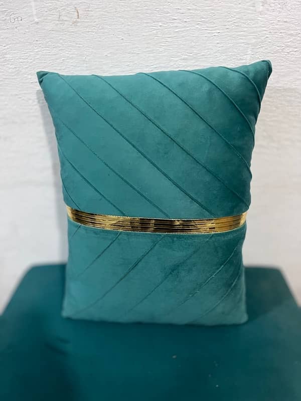 A rectangular teal velvet throw pillow with a vertical gold stripe 1