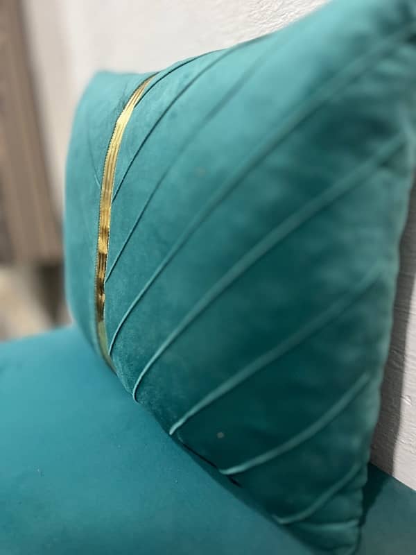 A rectangular teal velvet throw pillow with a vertical gold stripe 2