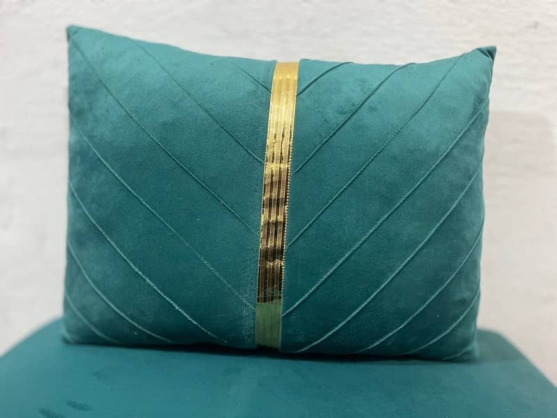 A rectangular teal velvet throw pillow with a vertical gold stripe 4