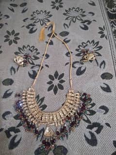 An artificial necklace with earings avlbl.