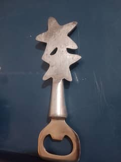 Starfish-shaped metal bottle opener, decorative and functional.