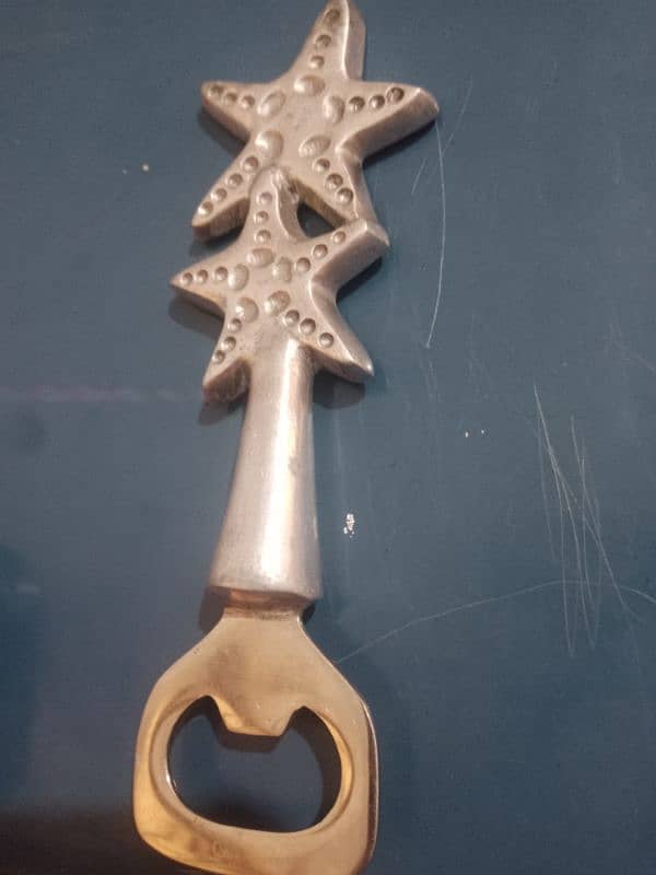 Starfish-shaped metal bottle opener, decorative and functional. 3