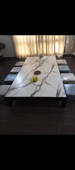 Floor sitting dining table with 8 wooden stools.