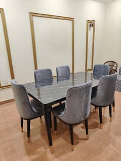 A brand new six seater dining table with a marble sheet on top