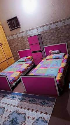 two single baby beds with side tables