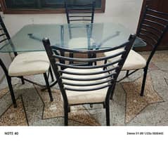 Metal and glass dinning table with four chairs in very good condition.