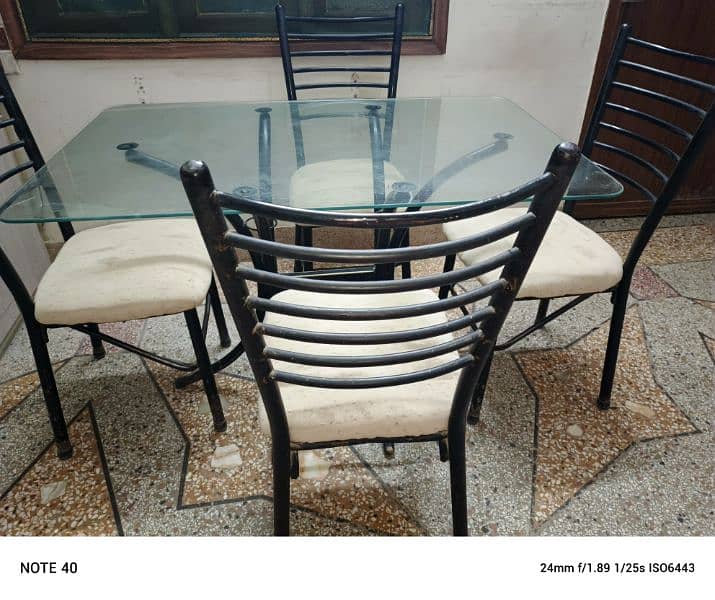 Metal and glass dinning table with four chairs in very good condition. 0