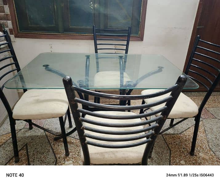Metal and glass dinning table with four chairs in very good condition. 1
