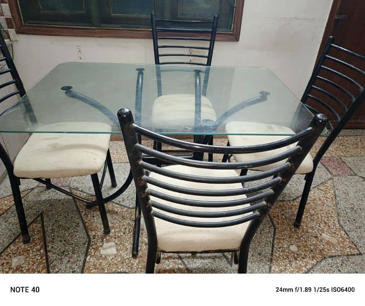 Metal and glass dinning table with four chairs in very good condition. 10