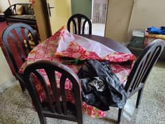 wooden dining table with four wooden chairs