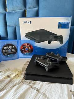 PS4 SLIM 1TB WITH 2 CONTROLLERS AND GAMES