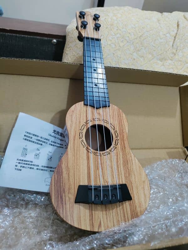 New small Ukulele with Box and pick 1