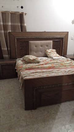 wooden bed with side tables and dressing table