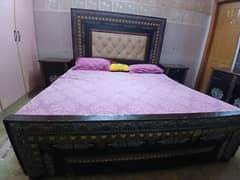 wooden bed with side table and dressing