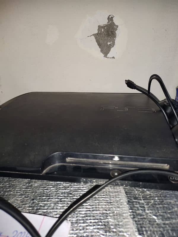 ps3 slim console with 2 wireless controller on it 0