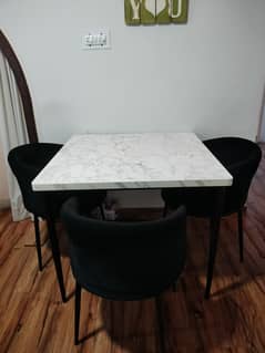 Wooden dining table with 3 chairs.