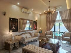 Outstanding Offer in DHA Phase 6 A 1-Year Used Fully Furnished 1-Kanal Bungalow with 5 Beds, Attached Baths, TV Lounge, Basement, Dual Kitchens, and 2 Servant Quarters Main Road Access with Easy Deal by Wall Green Realtors