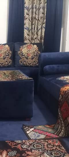 L shape sofa along with dewan, table, rug and curtains