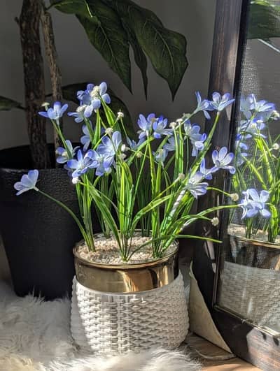 Artificial Potted plant with blue flowers.