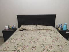 Quin size bed with side tables and spring mattress.