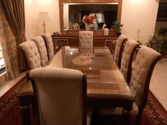 Solid wood table with 8 chairs available for sale.