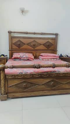 A WOODEN BED WITH SIDE TABLES AND DRESSING TABLES