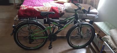 black and green mountain bike with gears and aerodynamic body