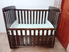 Wooden Baby cot with storage drawers and also mattress.