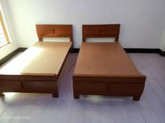 2 wooden single beds