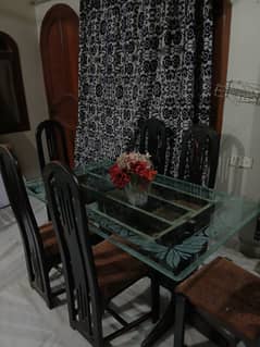 Glass table with 6 wooden chairs available